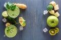 Fresh green smoothies with vegetables and fruits in a glass glass with ice on a black wooden table Royalty Free Stock Photo