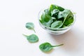 Fresh green spinach leaves in glass bowl on white table. Royalty Free Stock Photo