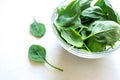 Fresh green spinach leaves in glass bowl on white table. Royalty Free Stock Photo