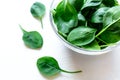 Fresh green spinach leaves in glass bowl on white table. Royalty Free Stock Photo