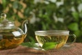 Fresh green tea in glass cup, teapot and leaves on bamboo mat Royalty Free Stock Photo