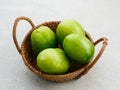 Fresh green tomatoes on rattan basket. Royalty Free Stock Photo