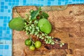 Fresh green unripe grapes, tangerines and mangoes on a wooden background in blue water and copy space Royalty Free Stock Photo