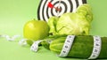 Fresh green vegetables and fruits wrapped in a measuring tape on a dart background.Concept of the goal to lose weight,the goal of