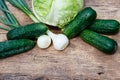 Fresh green vegetables on rustic wooden table. Cabbage, cucumbers and onion on wood table. Top view