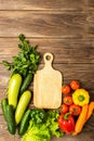 Fresh green vegetables zucchini cucumber greens pepper cutting board on wooden background. Healthy food vegetarianism. Royalty Free Stock Photo