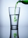 fresh green water flowing from plastic bottle into a glass Royalty Free Stock Photo