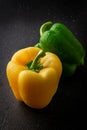 Fresh green and yellow paprika on a dark background