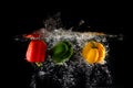 Fresh Green, Yellow and Red Bell Peppers with Water Splash and Bubble Isolated. Colorful Copy Space. Colored Paprika Dropped into Royalty Free Stock Photo