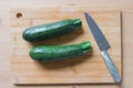 Fresh green zucchini on wooden board with knife. Cooking vegetables Royalty Free Stock Photo