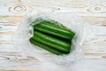 Cucumbers in plastic packaging on a wooden table Royalty Free Stock Photo