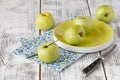 Fresh greenish apples in a dish on a rustic background.