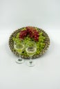 Fresh greens and red grapes in a basket with white wine glasses. Royalty Free Stock Photo