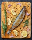 Fresh grey mullet fish lies on light wooden cutting board with l Royalty Free Stock Photo