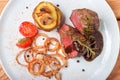 Fresh grilled bbq beef meat rib eye steak on white plate with baked potatoes, mushrooms, tomatoes,fried onion, hot chili pepper Royalty Free Stock Photo