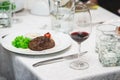 Fresh grilled bbq roast beef steak and sauce on a white plate with green leaf of salad. soup sauce small jug glass Royalty Free Stock Photo