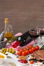 Fresh grilled meat. Grilled beef entrecote medium roast on black stone board, spice, olives oil, red wine and two full wine glasse Royalty Free Stock Photo