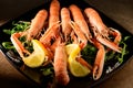 Fresh grilled shrimps served on a plate with arugula or rocket and llemon Royalty Free Stock Photo