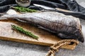 Fresh haddock fish carcass on the cutting Board. Gray background. Top view