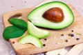 Fresh half sliced green avocado pieces ready to eat on brown wooden board background. Royalty Free Stock Photo