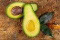 Fresh halves of ripe avocado with oil and leaves