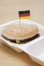 Fresh hamburger with German flag decoration on wooden surface