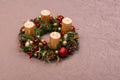 Fresh handmade Christmas wreath decorated with red and gold Christmas decorations, fir-cones and walnuts with gold candles Royalty Free Stock Photo