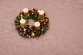 Fresh handmade Christmas wreath decorated with red and gold Christmas decorations, fir-cones and walnuts with gold candles Royalty Free Stock Photo