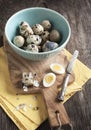 Fresh hard boiled quail eggs with shell beside on cooking board