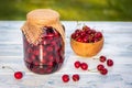 Fresh harvested cherries and preserved fruit in jar Royalty Free Stock Photo