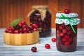 Fresh harvested cherries and preserved fruit in jar Royalty Free Stock Photo