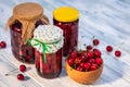 Fresh harvested cherries and preserved fruit in jar Royalty Free Stock Photo