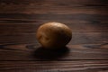 Fresh harvested potato on a rough wooden surface