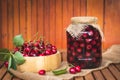 Fresh harvested red cherries and preserved fruit in jar Royalty Free Stock Photo