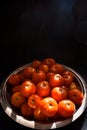 Fresh harvested sunkissed ripe red tomatoes kept in a rustic steel plate in a sunny place in kitchen. tomatoes for sauce, chutney Royalty Free Stock Photo