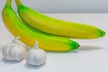 Fresh and healthy banana and garlic and white background Royalty Free Stock Photo