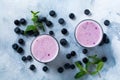 Fresh healthy blueberries smoothie berries and mint in glass on light white concrete background.