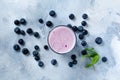 Fresh healthy blueberries smoothie berries and mint in glass on light white concrete background.