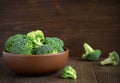 Fresh healthy broccoli in bowl on wooden table.
