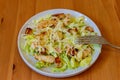 Fresh healthy caesar salad with chicken breast, lettuce, parmesan cheese, dressing and croutons on wooden table Royalty Free Stock Photo