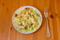 Fresh healthy caesar salad with chicken breast, lettuce, parmesan cheese, dressing and croutons on wooden table. Top view Royalty Free Stock Photo