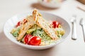 Fresh healthy caesar salad with chicken on white wooden table with fork and knife. Top view. Selective focus Royalty Free Stock Photo