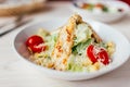 Fresh healthy caesar salad with chicken on white wooden table with fork and knife. Top view. Selective focus Royalty Free Stock Photo