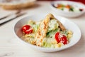 Fresh healthy caesar salad with chicken on white wooden table with fork and knife. Top view. Selective focus Royalty Free Stock Photo