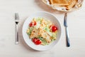 Fresh healthy caesar salad with chicken on white wooden table with fork and knife. Top view. Selective focus. Royalty Free Stock Photo