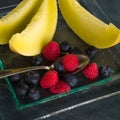 Fresh healthy fruit on a glass dessert plate on black background. Healthy eating concept Royalty Free Stock Photo