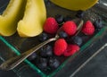 Fresh healthy fruit on a glass dessert plate on black background. Healthy eating concept Royalty Free Stock Photo