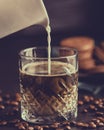 Fresh healthy milk pouring from the jug into a glass off cold latte and chocolate coffee cookies Royalty Free Stock Photo