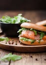 Fresh healthy organic sandwich with salmon and bagel, cream cheese and wild rocket in plate on wooden table background Royalty Free Stock Photo