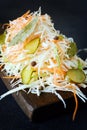 Fresh healthy salad - cabbage, carrot, pickle. Coleslaw on a wooden board on a light background. Vegetables for ferment